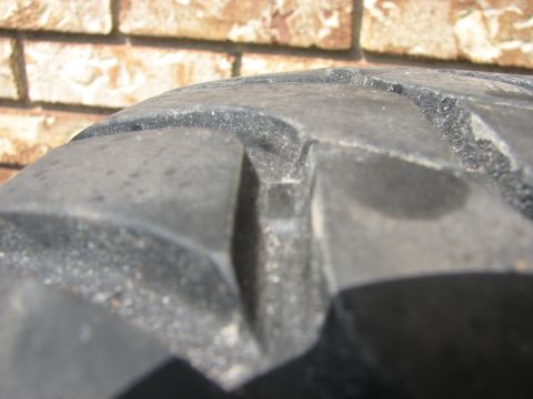 2003 Ford Crown Victoria - A close-up view of a tire's tread pattern is shown against a brick wall background.