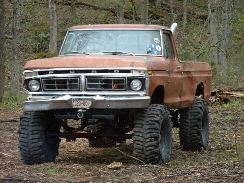 1988 Ford Bronco - This lifted Ford truck features a prominent grille and snorkel exhaust, indicating an older model year.