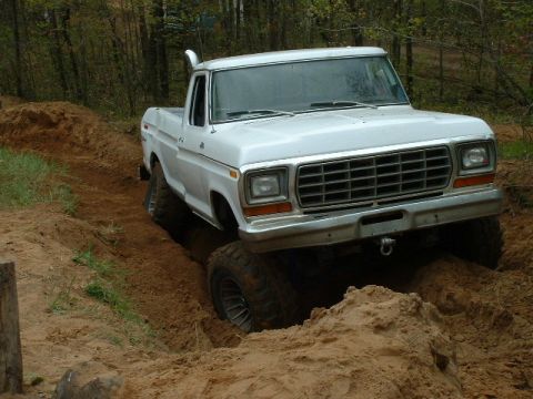 1988 Ford Bronco - This lifted 1979 Ford F-Series pickup truck is shown off-roading through a sandy track, demonstrating its off-road capabilities.