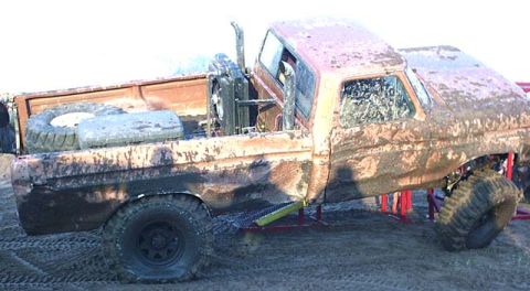 1988 Ford Bronco - This heavily modified pickup truck appears to be from the early 1980s, a snorkel exhaust and a spare tire mounted in the bed.