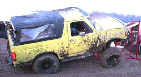 1988 Ford Bronco - This heavily modified SUV is covered in mud, suggesting it has been used for off-roading.