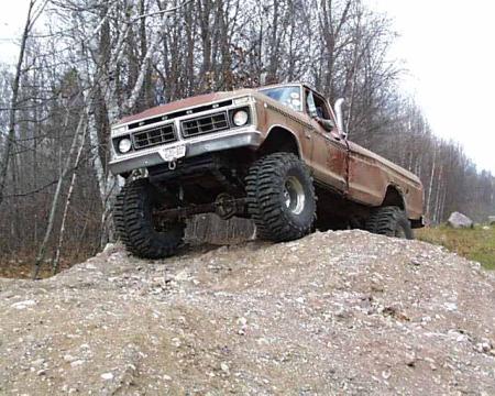 1988 Ford Bronco - This lifted Ford pickup truck is shown off-road on a dirt mound.