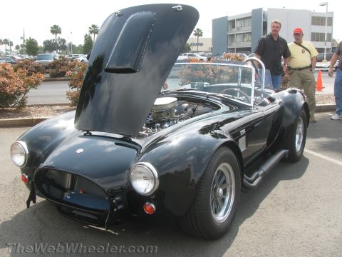 1968 Ford Mustang - AC Cobra roadster with hood open, revealing the engine. Side pipes are prominent.