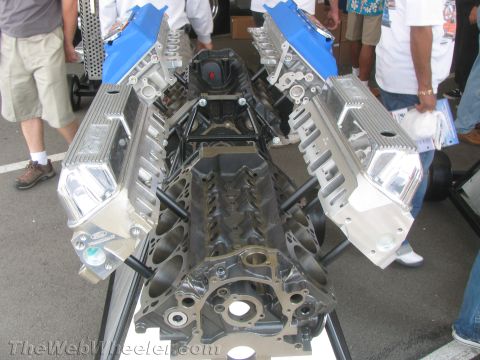 1968 Ford Mustang - A V8 engine block is shown with polished aluminum valve covers and blue intake manifolds.