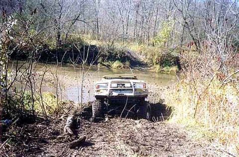 1988 Ford Bronco - This 1988 Ford Bronco is stuck in the mud near a creek, viewed from the rear.