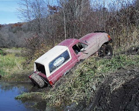 1988 Ford Bronco - This vehicle appears to be stuck in a muddy embankment next to a body of water.