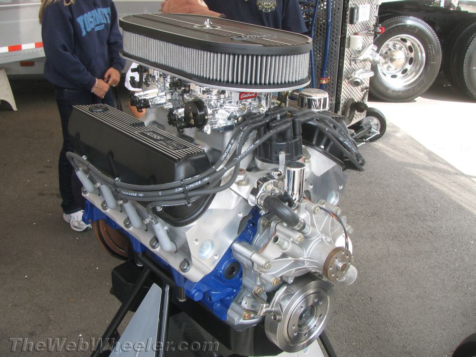 Ford V8 engine with chrome air cleaner and black valve covers on a stand