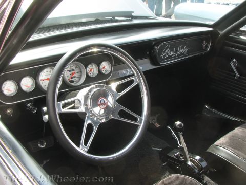 1968 Ford Mustang - The interior of a 1965 Shelby Mustang features a custom steering wheel, racing gauges, and Carroll Shelby's signature on the dashboard.