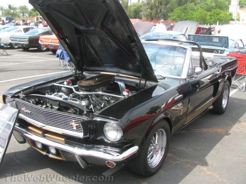 1968 Ford Mustang - A black 1966 Ford Mustang convertible is displayed with its hood open, revealing the engine bay.