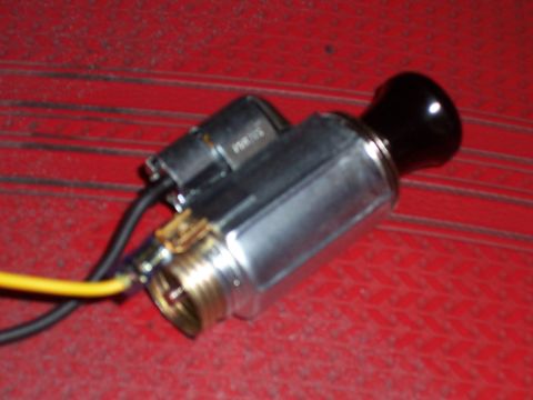 1978 Ford Bronco - Close-up of a car's cigarette lighter assembly, showing wiring and metal components.