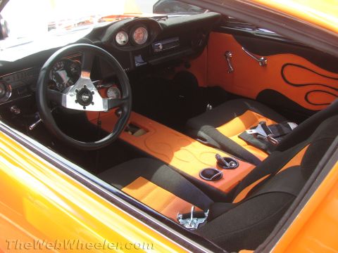 1968 Ford Mustang - The interior of the car features custom orange and black upholstery with flame graphics on the door panels and center console.