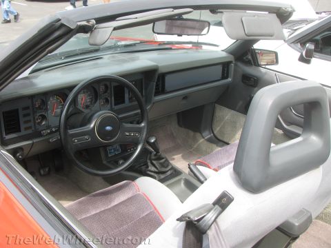 1968 Ford Mustang - Interior of a convertible, a gray dashboard, steering wheel, and seats with red trim.