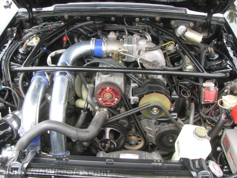 1968 Ford Mustang - Close-up view of a modified engine bay a supercharger and polished intake piping.