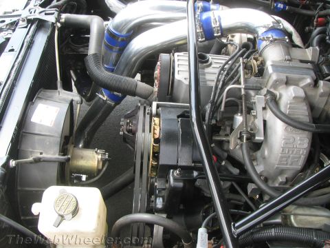 1968 Ford Mustang - Close-up of a modified engine bay turbocharger plumbing and a 2.3L EFI intake manifold.