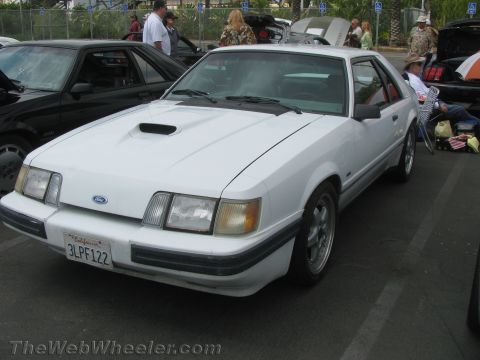 1968 Ford Mustang - White 1980s Ford Mustang parked at an outdoor event with other vehicles.
