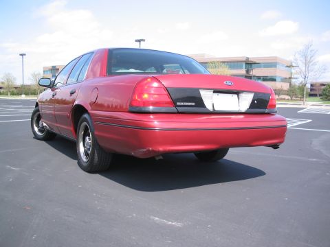 2001 Ford Crown Victoria - Rear view of a red 2001 Ford Crown Victoria parked outdoors.