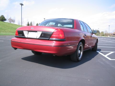 2001 Ford Crown Victoria - This red 2001 Ford Crown Victoria is shown from the rear 3/4 angle in a parking lot.