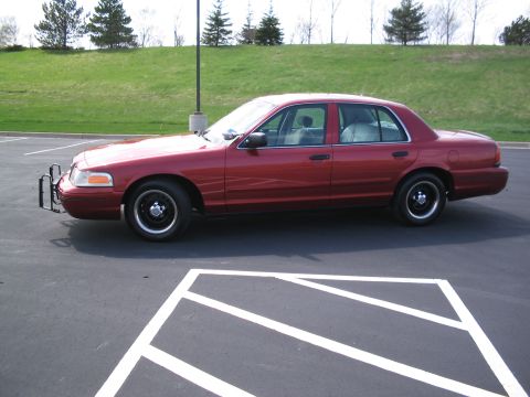 2001 Ford Crown Victoria - Side view of a red 2001 Ford Crown Victoria sedan equipped with a push bumper.