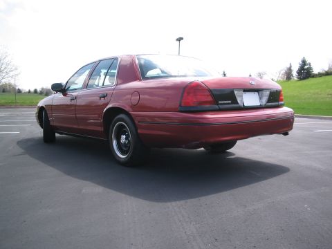 2001 Ford Crown Victoria - Rear view of a red 2001 Ford Crown Victoria sedan parked outdoors.