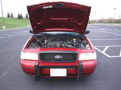 2001 Ford Crown Victoria - Front view of a red 2001 Ford Crown Victoria with its hood open, revealing the engine compartment.