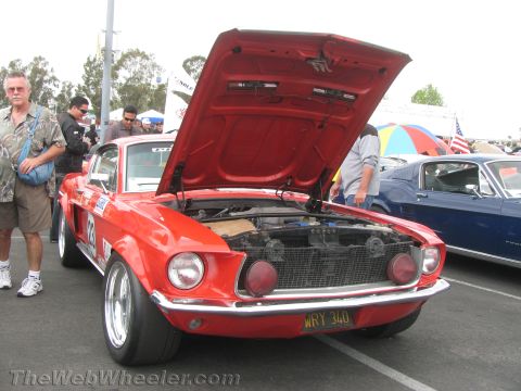 1968 Ford Mustang - A red 1968 Ford Mustang is displayed with its hood open, revealing the engine bay and a license plate reading WR Y 340.