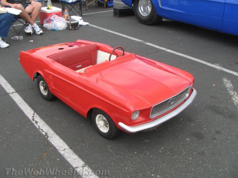 1968 Ford Mustang - A red toy car, styled like a 1968 Ford Mustang, is seen outdoors next to a blue vehicle.