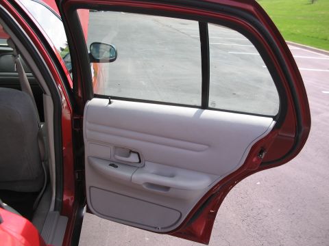 2001 Ford Crown Victoria - Interior view of a red 2001 Ford Crown Victoria showing the door panel and open rear door.