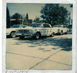 1963 Ford Galaxie - Three cars are parked on a sunny day, with the front of a 1963 Ford Galaxie prominently displayed.
