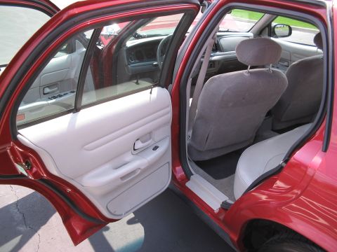 2001 Ford Crown Victoria - Interior view of a red 2001 Ford Crown Victoria, highlighting the grey cloth seats and door panels.