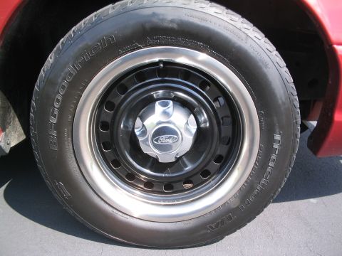 2001 Ford Crown Victoria - A close-up view of a vehicle's wheel and tire, a Ford logo on the hubcap.