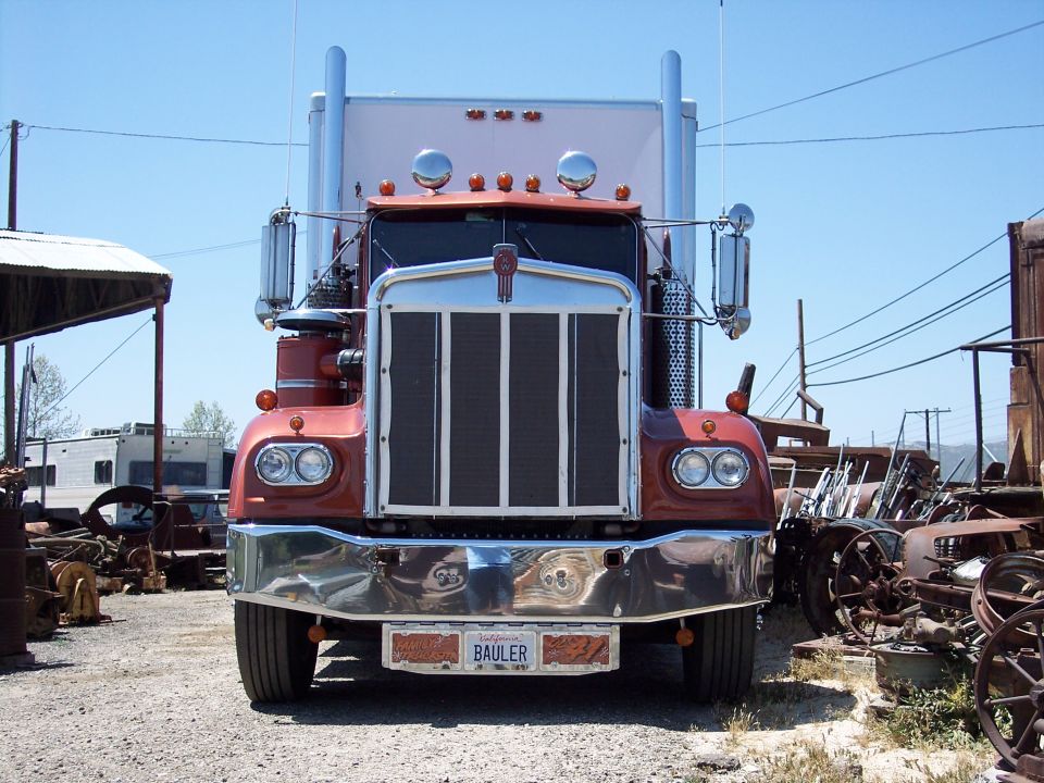 1981 Kenworth W900A semi-truck front view, red cab, chrome bumper, California license plate BAULER