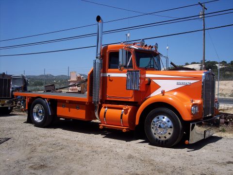 1981 Kenworth W900A - This orange 1981 Kenworth W900A flatbed truck is viewed from the front-three-quarter angle.