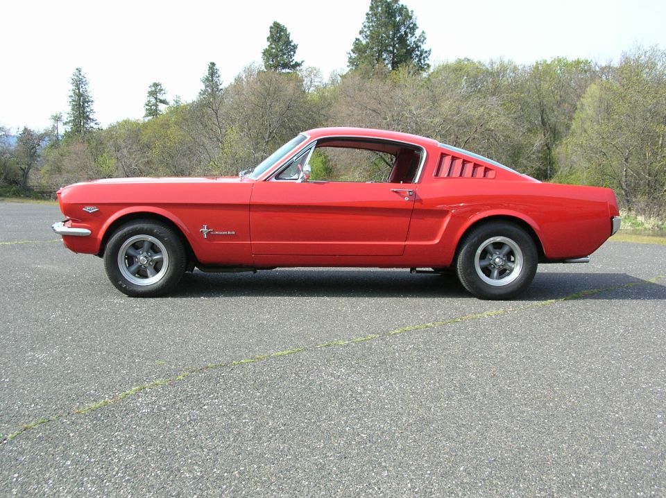 Red Ford Mustang fastback, driver-side profile view