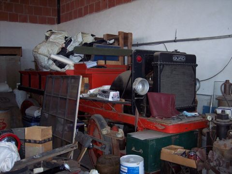 1981 Kenworth W900A - This red truck features a prominent black grille with the "QUAD" label and a red seat, seen in a cluttered garage.