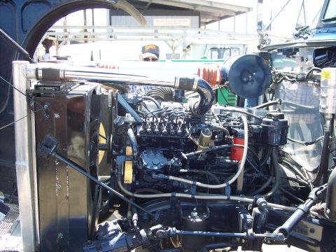 1981 Kenworth W900A - Close-up view of a truck's engine bay, a prominent chrome exhaust pipe and various engine components.