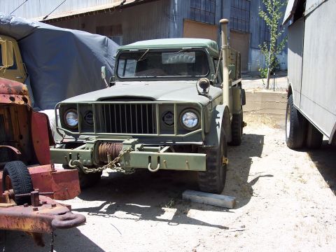1981 Kenworth W900A - A military truck with a winch is parked in an outdoor lot next to other vehicles.