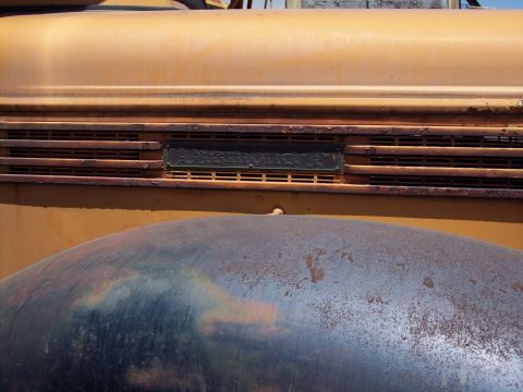 1981 Kenworth W900A - Close-up of a yellow truck's grille and fender, showing horizontal vents and a dark nameplate.