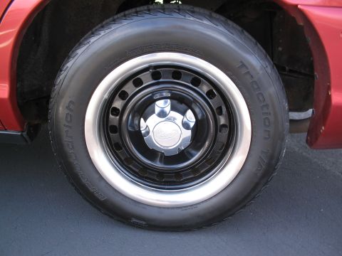 2001 Ford Crown Victoria - Close-up of a vehicle's wheel and tire, showing a Ford logo on the hubcap.