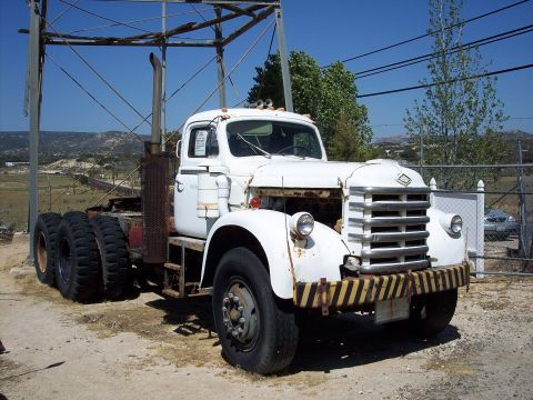 1981 Kenworth W900A - This old truck cab sits under a metal frame structure on a sunny day, with hills in the background.