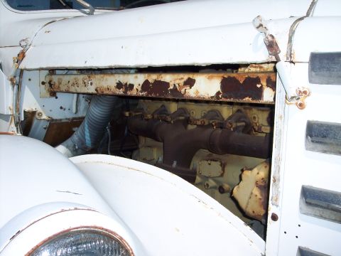 1981 Kenworth W900A - The engine compartment of a white truck shows significant rust on the bracing above the engine block.