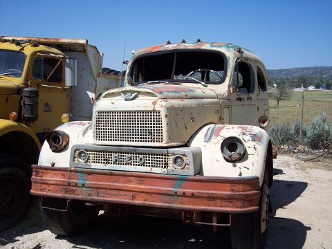 1981 Kenworth W900A - A vintage truck sits in a yard, showing signs of age and wear, with another vehicle nearby.