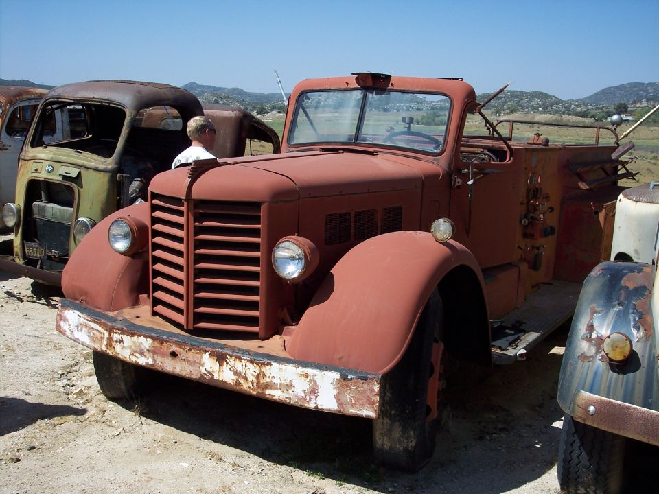 Red fire truck with horizontal grille, round headlights, and a white bumper