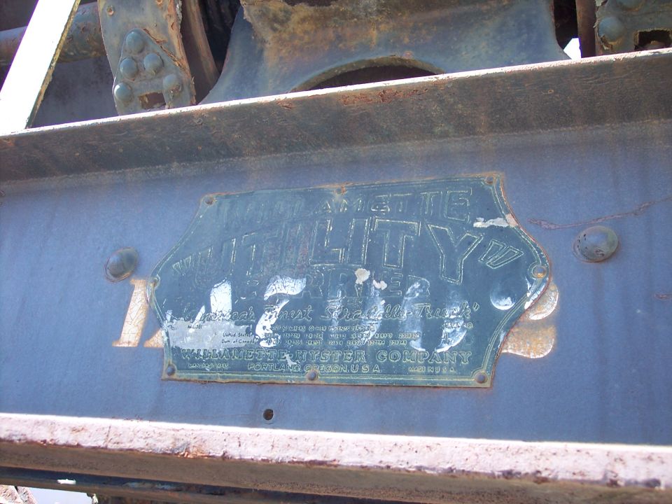 Weathered Willamette Hyster Company straddle-truck builder's plate on rusty steel frame