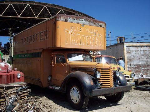 1981 Kenworth W900A - An old-fashioned moving truck with 'GRASS VALLEY TRANSFER' painted on its side is parked outdoors.