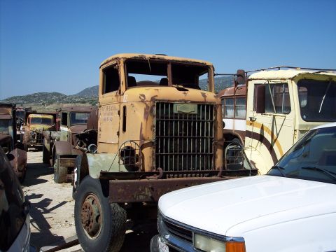 1981 Kenworth W900A - This old truck sits in a yard full of other vehicles under a clear blue sky.