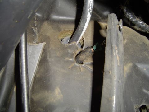 1989 Ford Bronco - This image shows a close-up view of a vehicle's interior, focusing on a plastic component and a cable assembly.