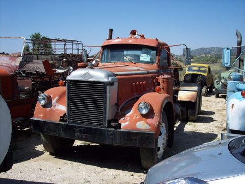 1981 Kenworth W900A - This old truck is parked in a yard with several other vehicles, under a clear blue sky.