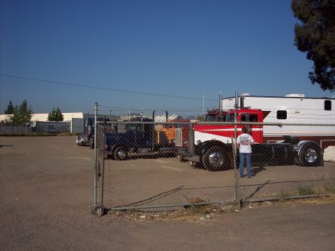 1981 Kenworth W900A - A 1981 Kenworth W900A semi-truck with a distinctive red and white paint scheme is parked alongside a blue semi-truck under a clear blue sky.