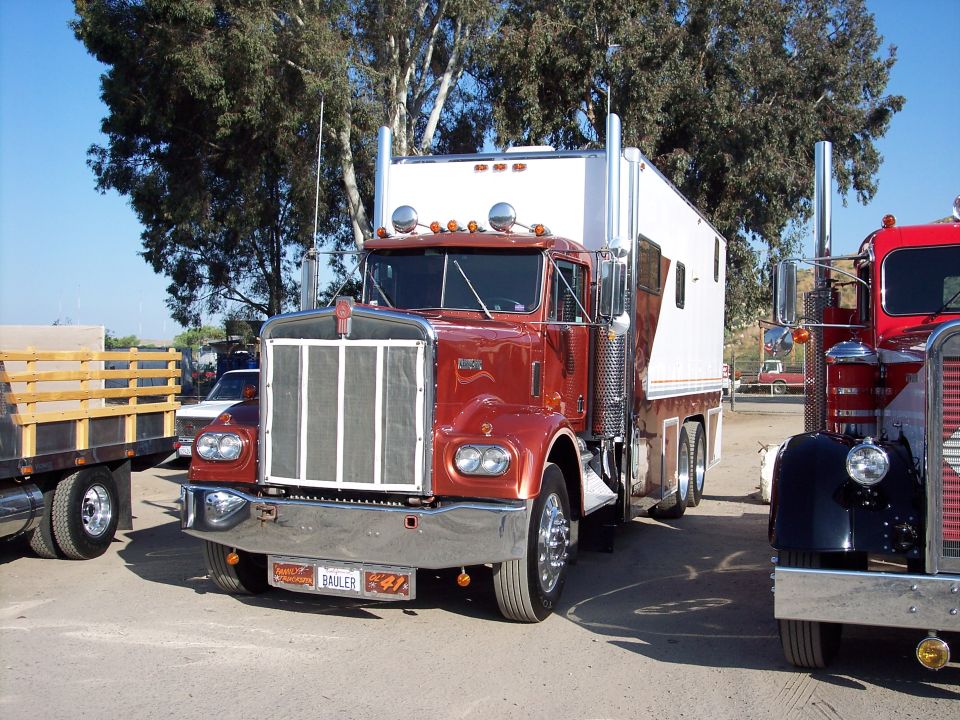 1981 Kenworth W900A semi-truck parked next to another red semi-truck