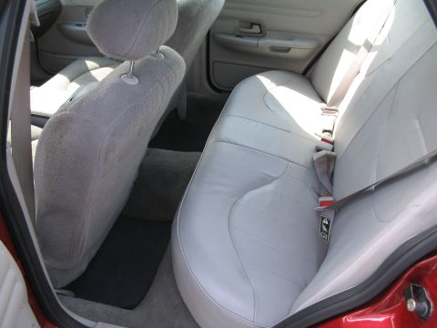 2001 Ford Crown Victoria - Rear interior view of a 2001 Ford Crown Victoria, showing the light gray leather seats and seatbelts.